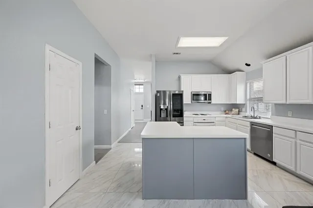 a kitchen with stainless steel appliances a sink stove and refrigerator