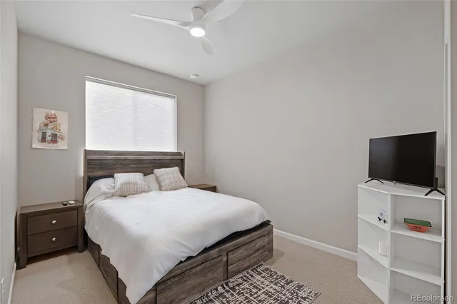 a bedroom with a bed and a flat tv screen on wall