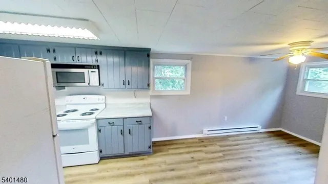 a kitchen with a sink cabinets and wooden floor