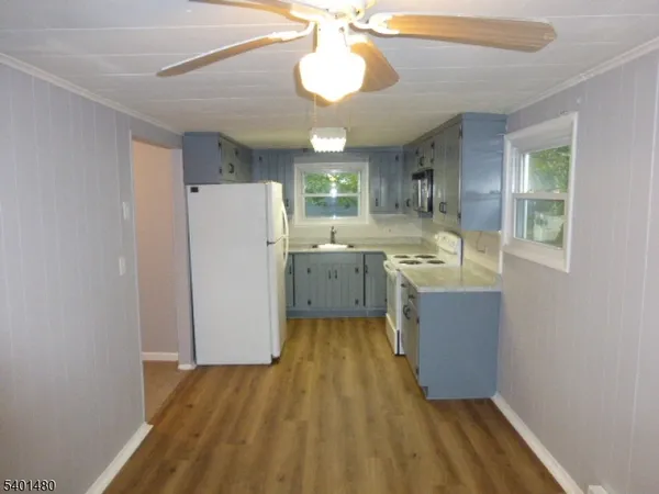 a kitchen with wooden floors and refrigerator