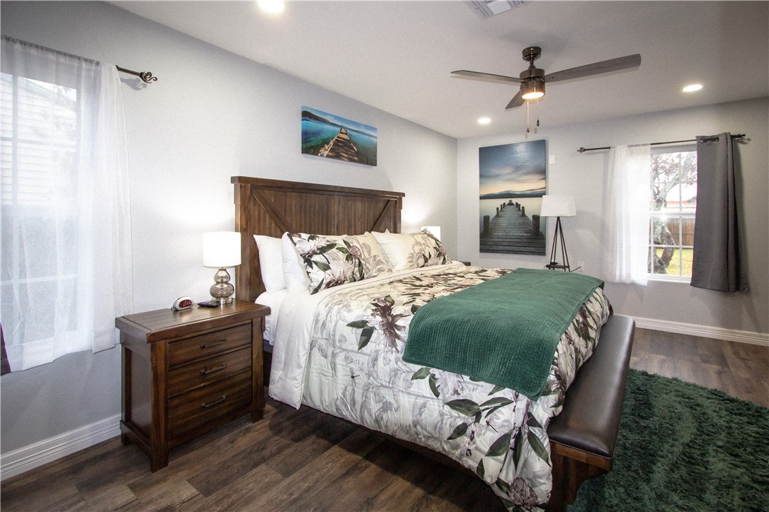 1505 Dewitt Street Corpus Christi, TX 78418 - Photo 13 of 18 a bed sitting in a bedroom next to a window and a chandelier