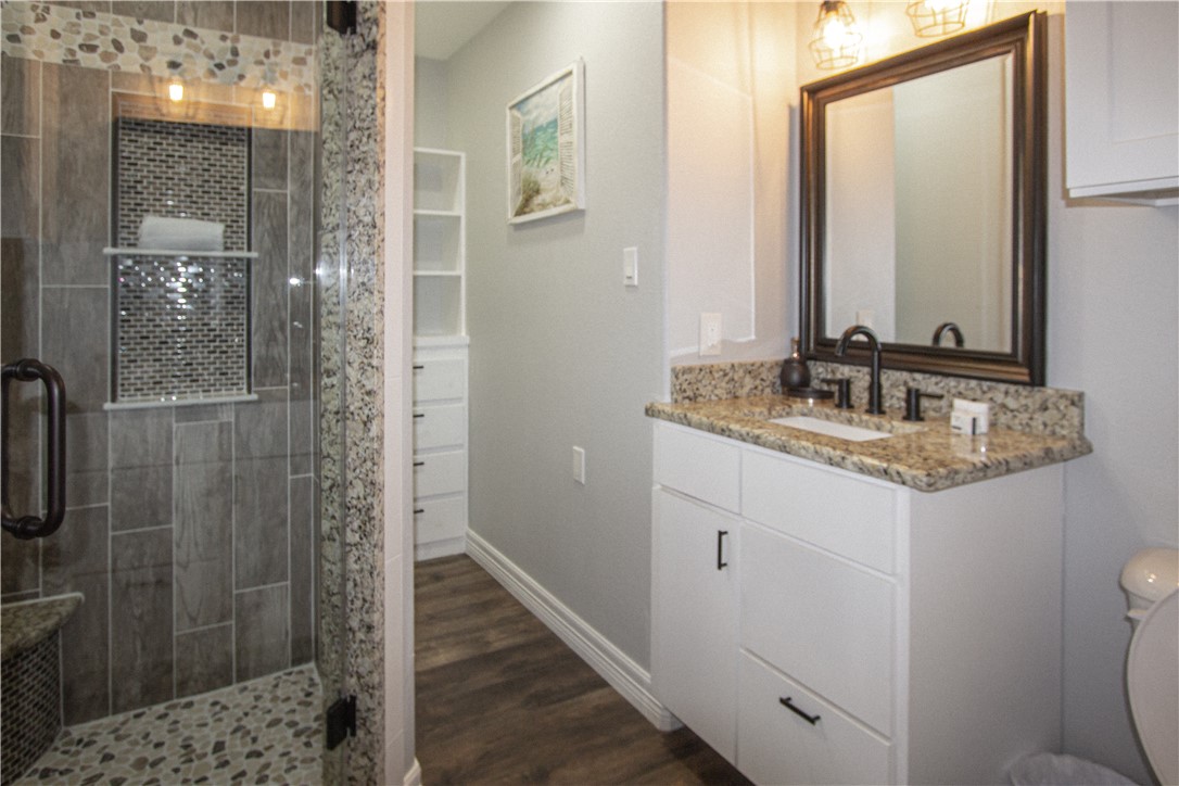 1505 Dewitt Street Corpus Christi, TX 78418 - Photo 15 of 18 a bathroom with a granite countertop sink a mirror and shower