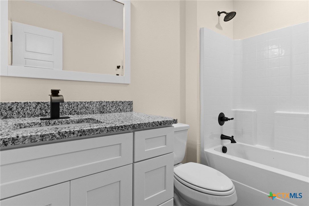 5222 Rose Gdn Loop Killeen, TX 76542 - Photo 12 of 25 a bathroom with a granite countertop toilet a sink and bathtub