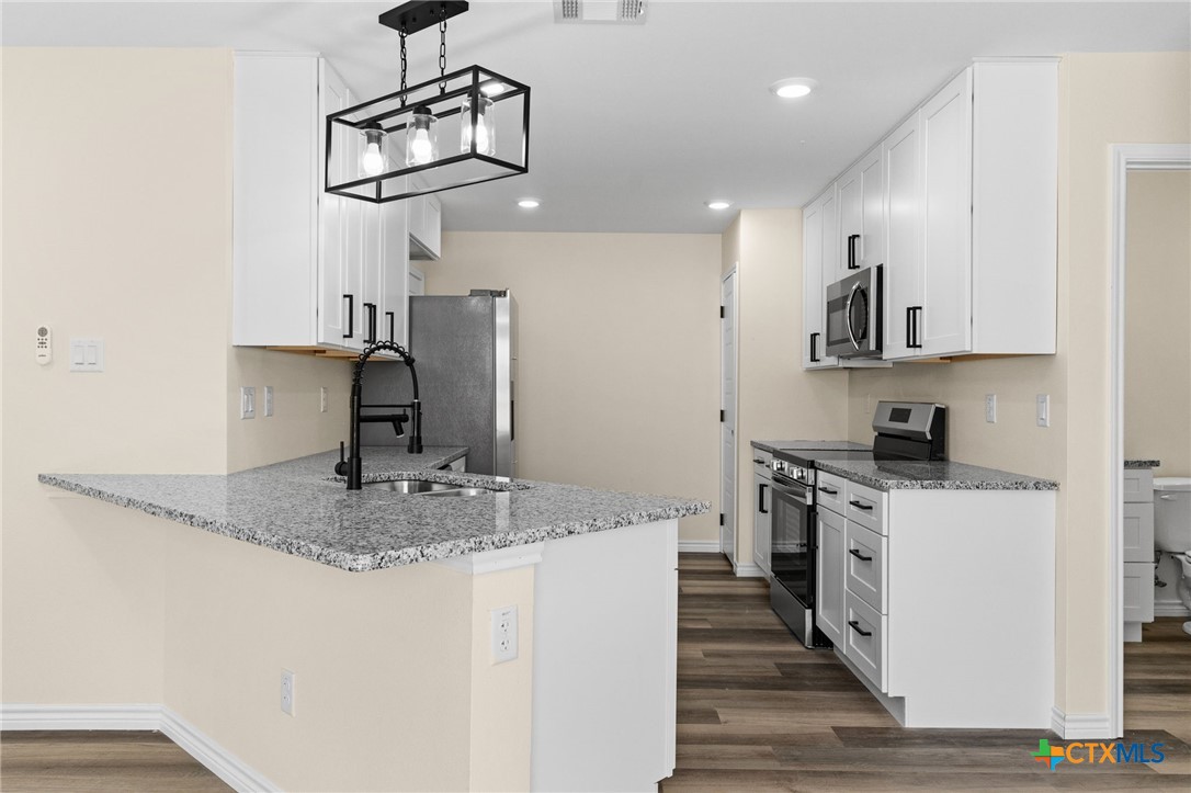 5222 Rose Gdn Loop Killeen, TX 76542 - Photo 8 of 25 a kitchen with stainless steel appliances granite countertop a sink a stove and a refrigerator