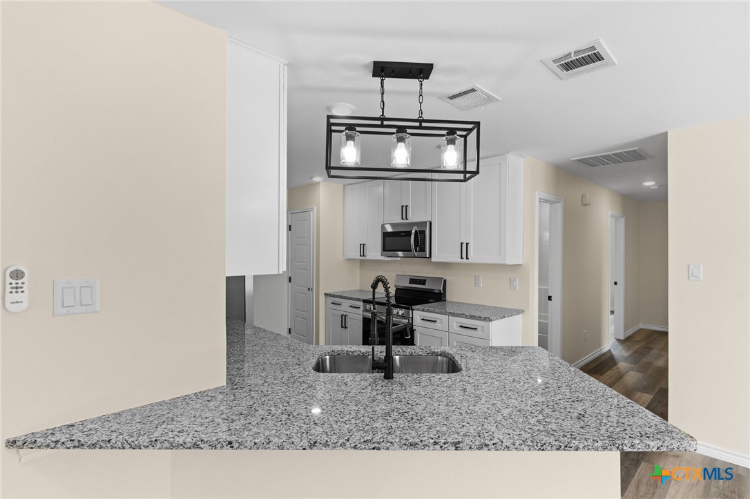 5222 Rose Gdn Loop Killeen, TX 76542 - Photo 9 of 25 a kitchen with a sink a stove and cabinets