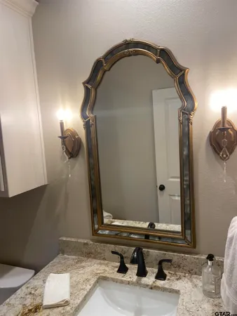 a bathroom with a granite countertop sink and a mirror