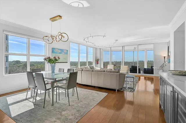 a living room with furniture a large window and wooden floor