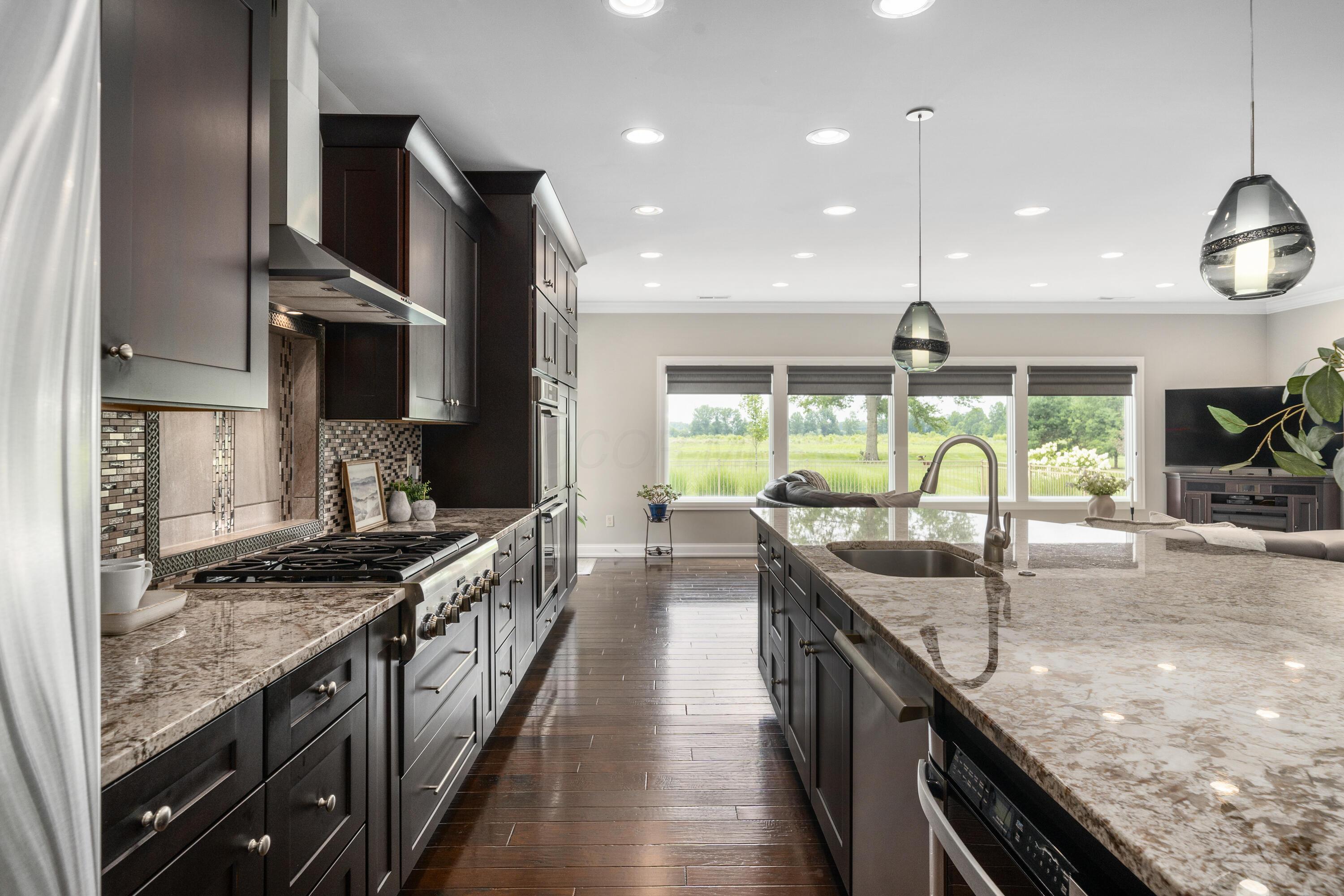 4640 Maynard Road Delaware, OH 43015 - Photo 17 of 91 Gourmet kitchen featuring granite countertops, a tiled backsplash, stainless steel appliances, and a central island with a sink