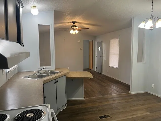 a view of a kitchen with a sink and chandelier