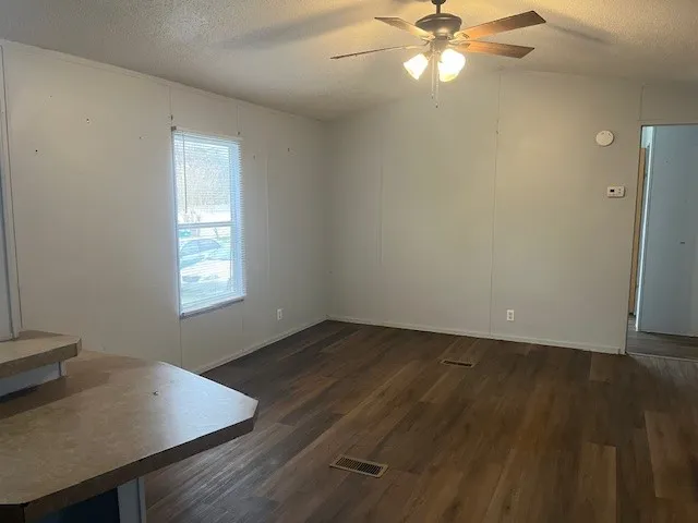 a view of a workspace with wooden floor and a window