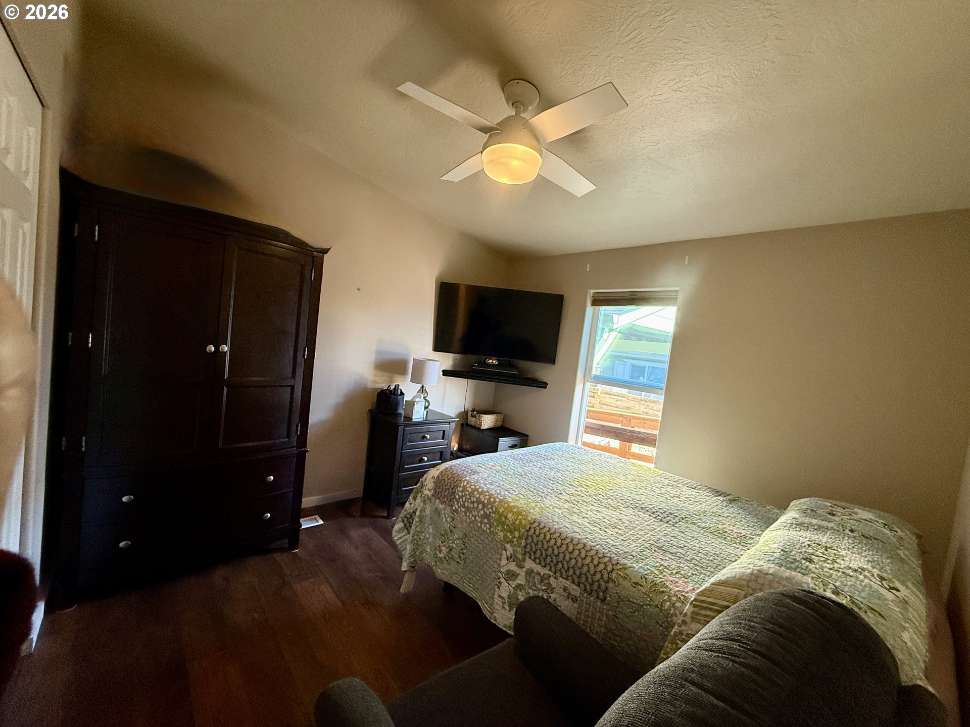 3050 Knott Terrace Coos Bay, OR 97420 - Photo 18 of 24 a bedroom with a bed and a flat tv screen on dresser