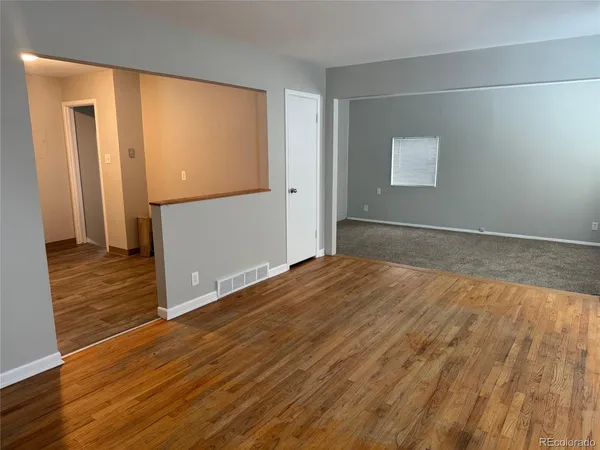 a view of empty room with wooden floor