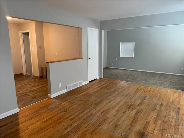 a view of empty room with wooden floor