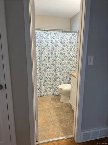 a bathroom with a toilet and a shower curtain