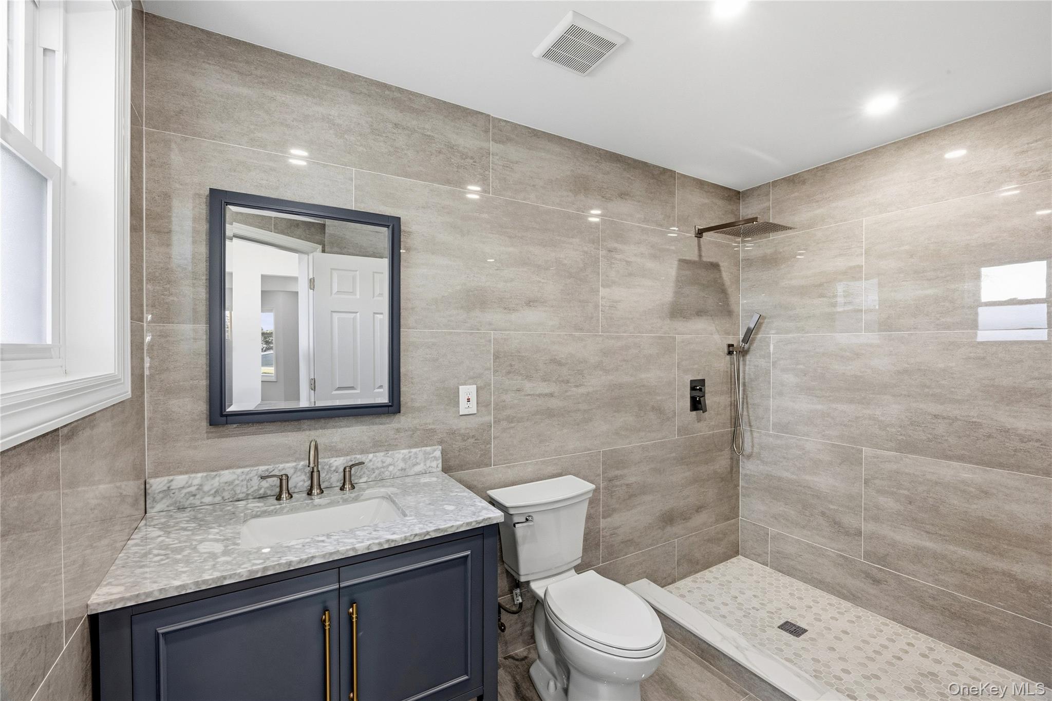 22 Colonial Avenue Freeport, NY 11520 - Photo 13 of 41 a bathroom with a granite countertop sink toilet a mirror and shower