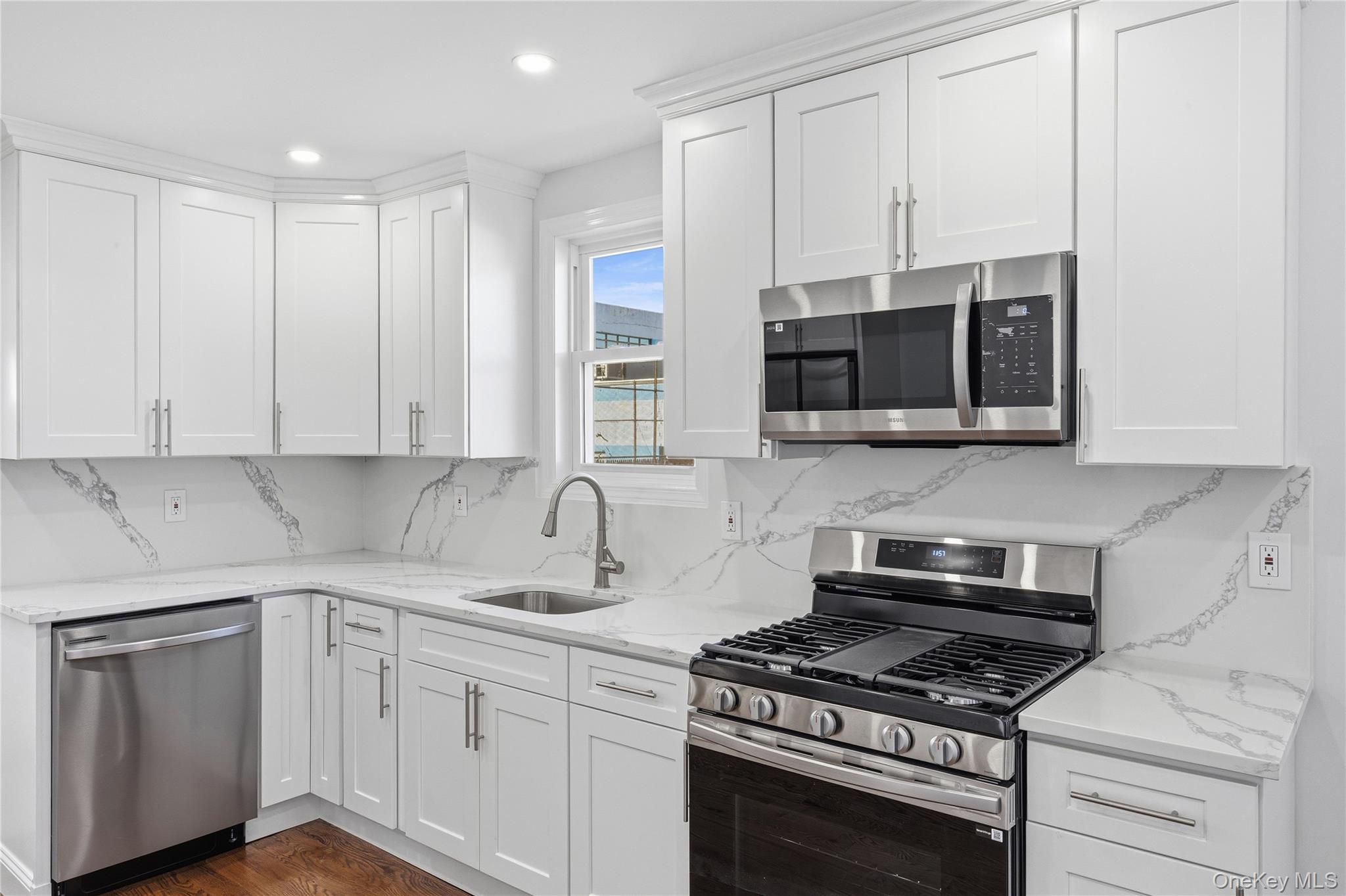 22 Colonial Avenue Freeport, NY 11520 - Photo 15 of 41 a kitchen with stainless steel appliances a stove a microwave and cabinets