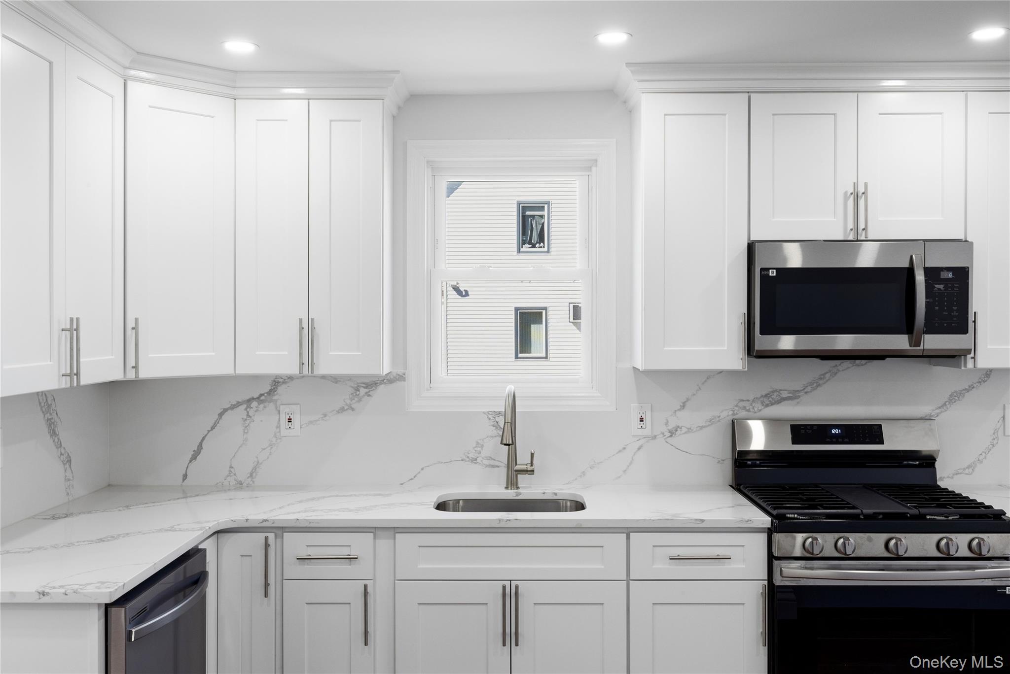 22 Colonial Avenue Freeport, NY 11520 - Photo 20 of 41 a kitchen with stainless steel appliances granite countertop a sink a stove and a microwave