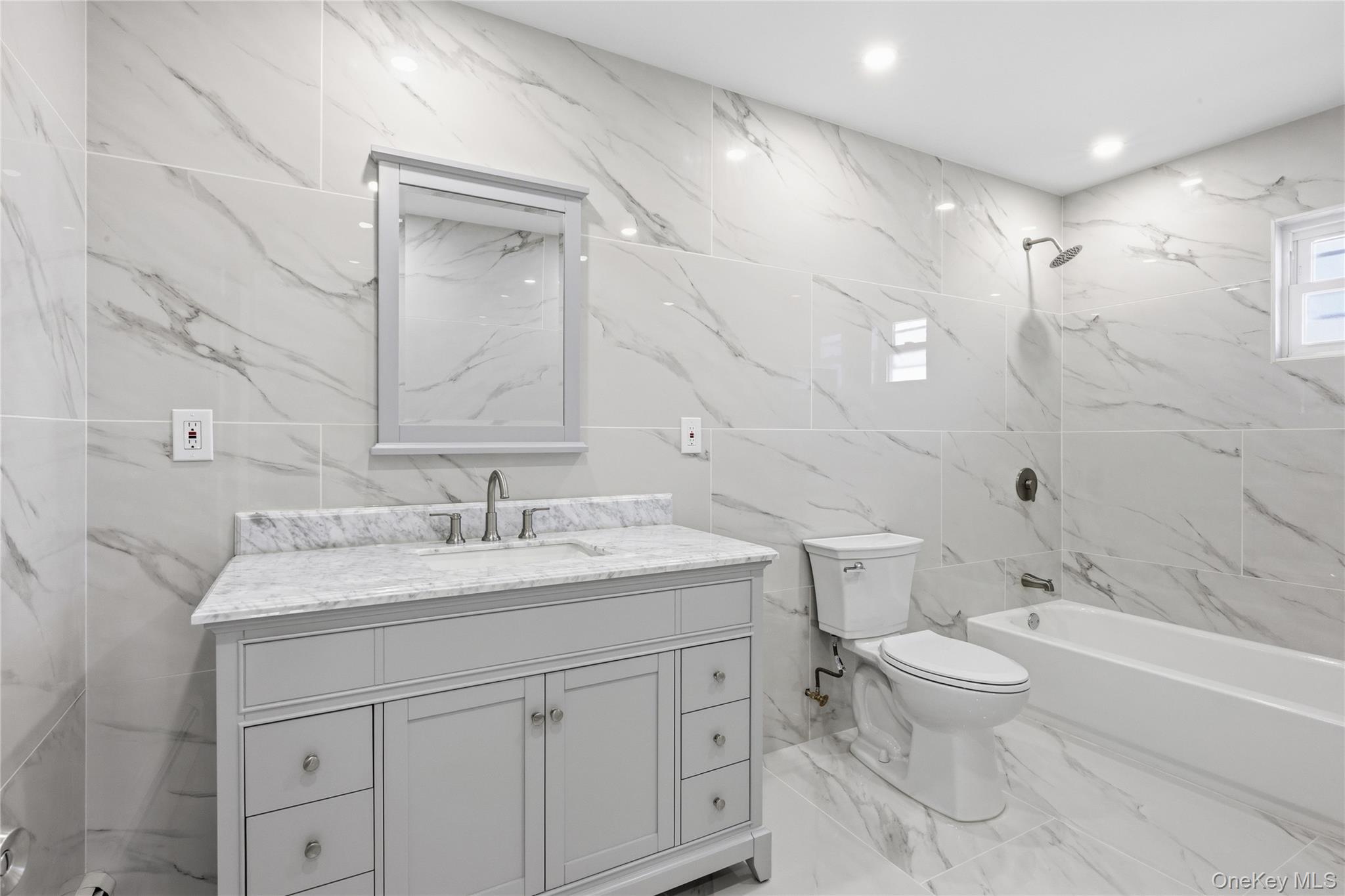 22 Colonial Avenue Freeport, NY 11520 - Photo 29 of 41 a bathroom with a granite countertop sink a toilet and a bathtub