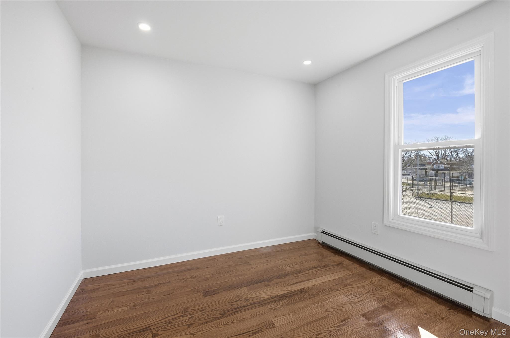 22 Colonial Avenue Freeport, NY 11520 - Photo 34 of 41 an empty room with wooden floor and windows