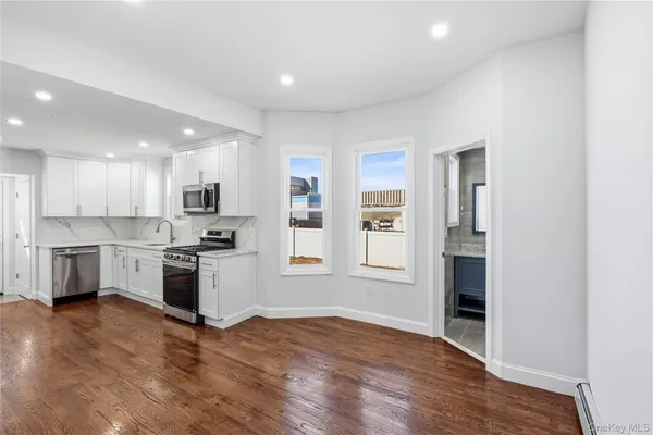 a open kitchen with white cabinets and stainless steel appliances