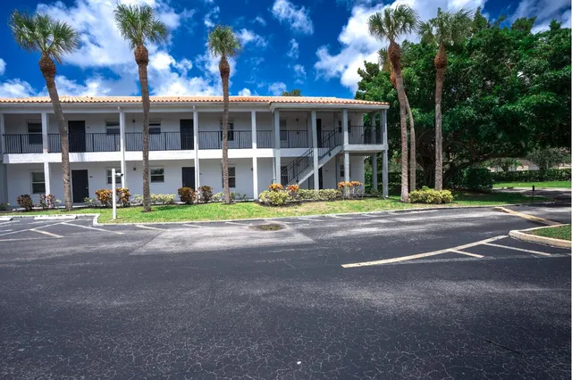 a front view of a building with street and trees