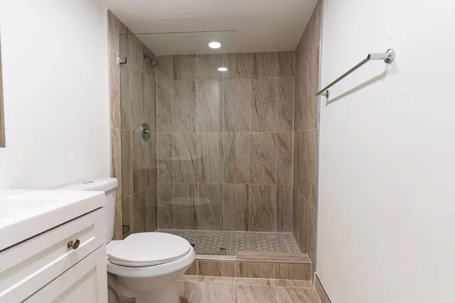 a bathroom with a shower a toilet and a sink