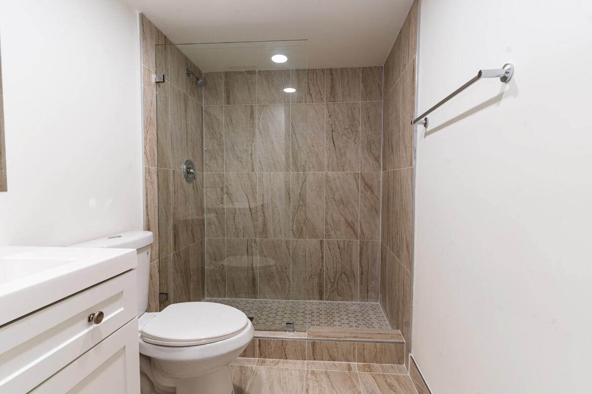 5458 Via Delray Boulevard, Unit 110 Delray Beach, FL 33484 - Photo 24 of 30 a bathroom with a shower a toilet and a sink