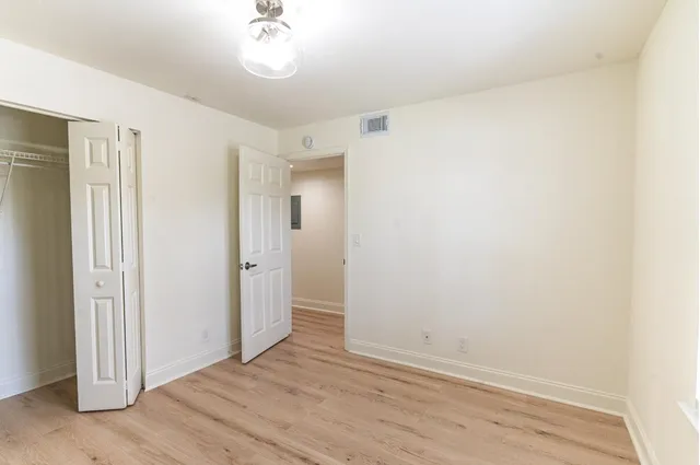 a view of a room with wooden floor and a bathroom