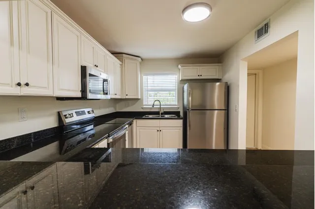 a kitchen with a refrigerator and a stove top oven