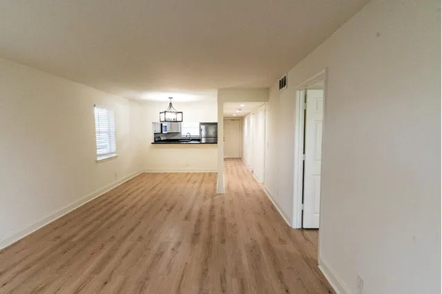 a view of a room with wooden floor and a window