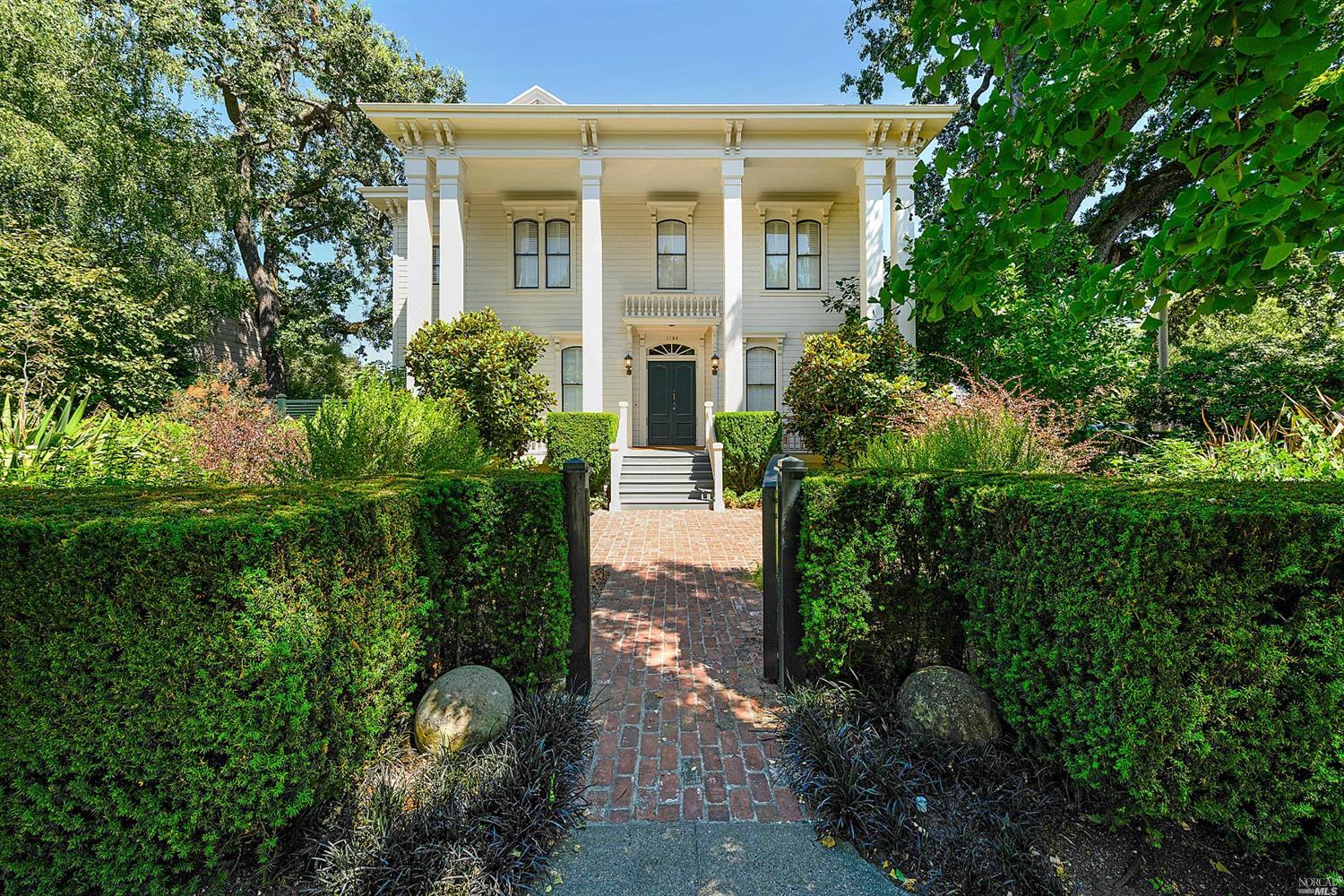 a front view of a house with a yard and potted plants