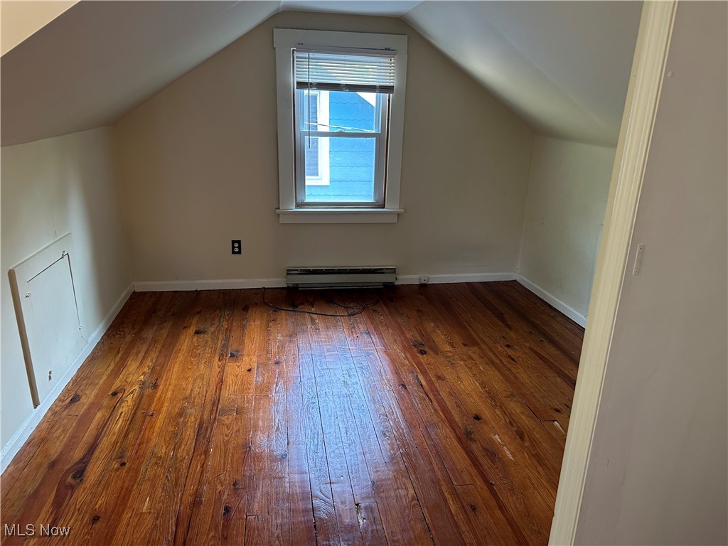1596 Wood Road Cleveland Heights, OH 44121 - Photo 7 of 25 Additional living space with wood-type flooring, lofted ceiling, and a baseboard radiator