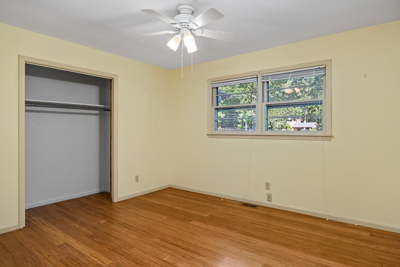 5815 Paragon Circle Durham, NC 27712 - Photo 23 of 41 an empty room with wooden floor chandelier fan and windows