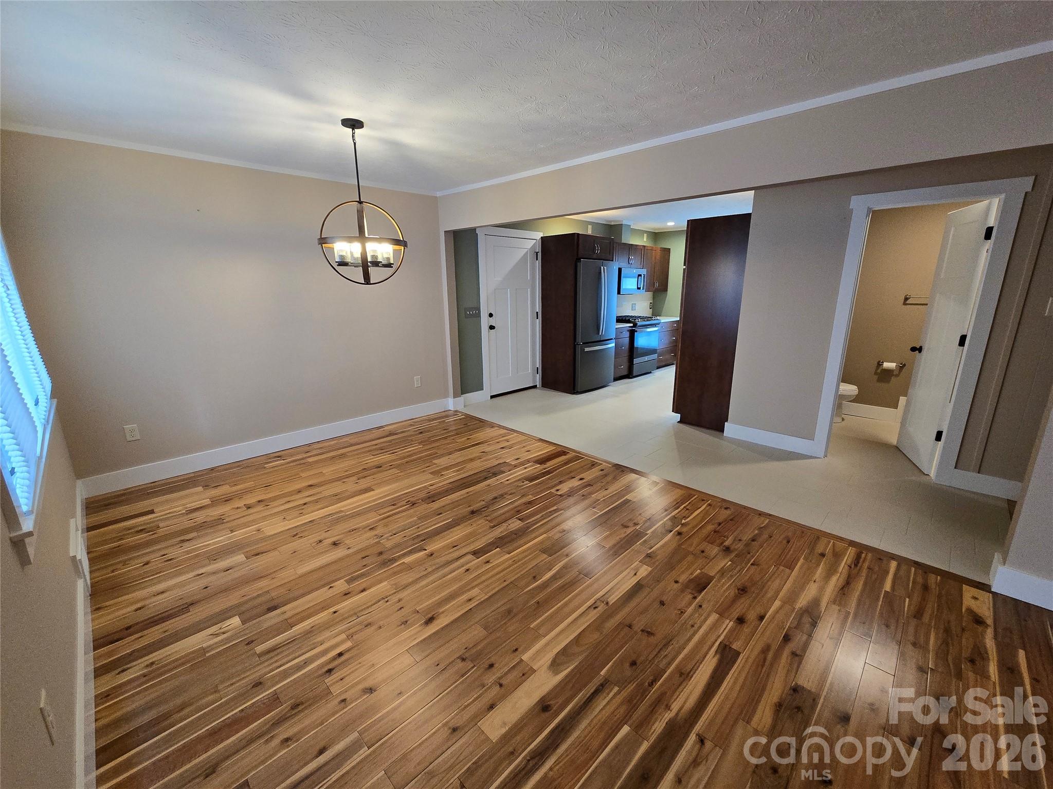 100 Chapel Road Black Mountain, NC 28711 - Photo 17 of 30 a view of an empty room with wooden floor kitchen view and a window