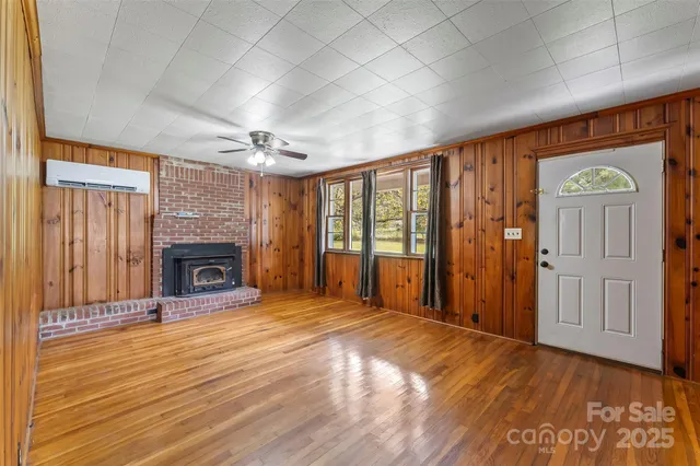 a view of an empty room with a fireplace and a window