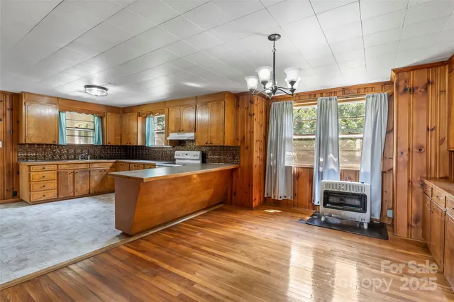 a large kitchen with a lot of counter space and a wooden floor