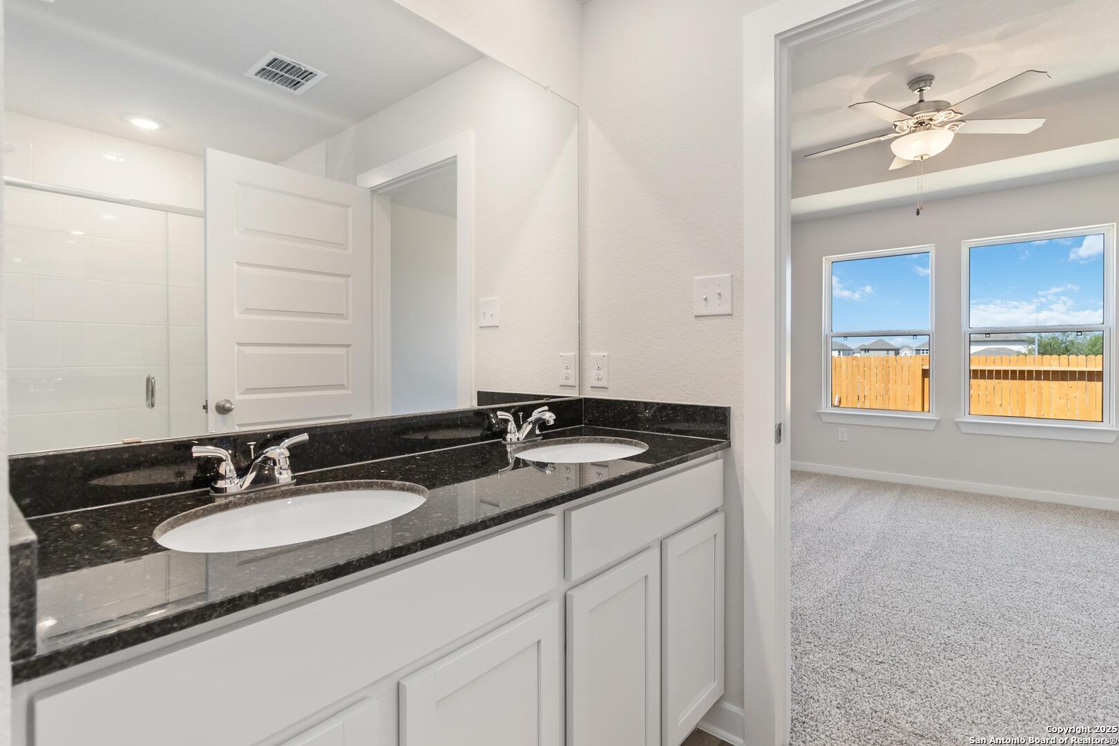 10303 Apple Pie Road San Antonio, TX 78224 - Photo 17 of 31 a bathroom with a granite countertop sink and a mirror