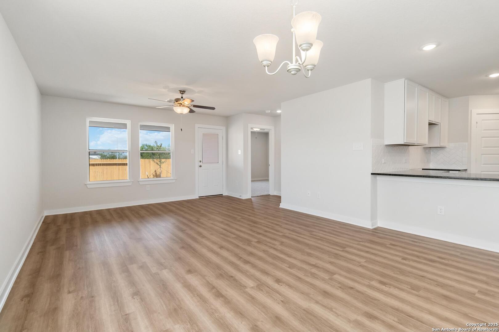 10303 Apple Pie Road San Antonio, TX 78224 - Photo 7 of 31 a view of an empty room with wooden floor and kitchen view