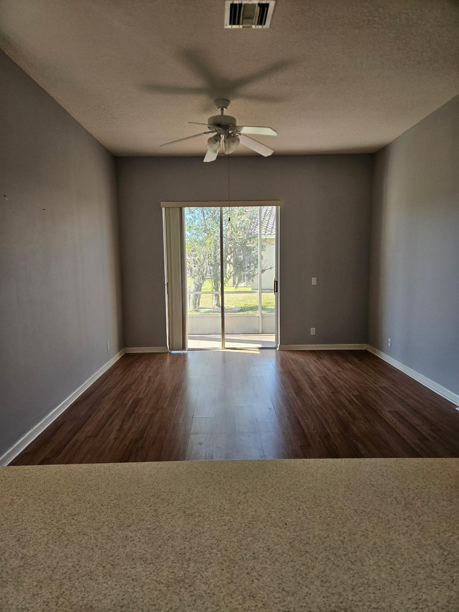 406 Springview Loop Port St. Lucie, FL 34986 - Photo 14 of 23 an empty room with wooden floor chandelier and windows
