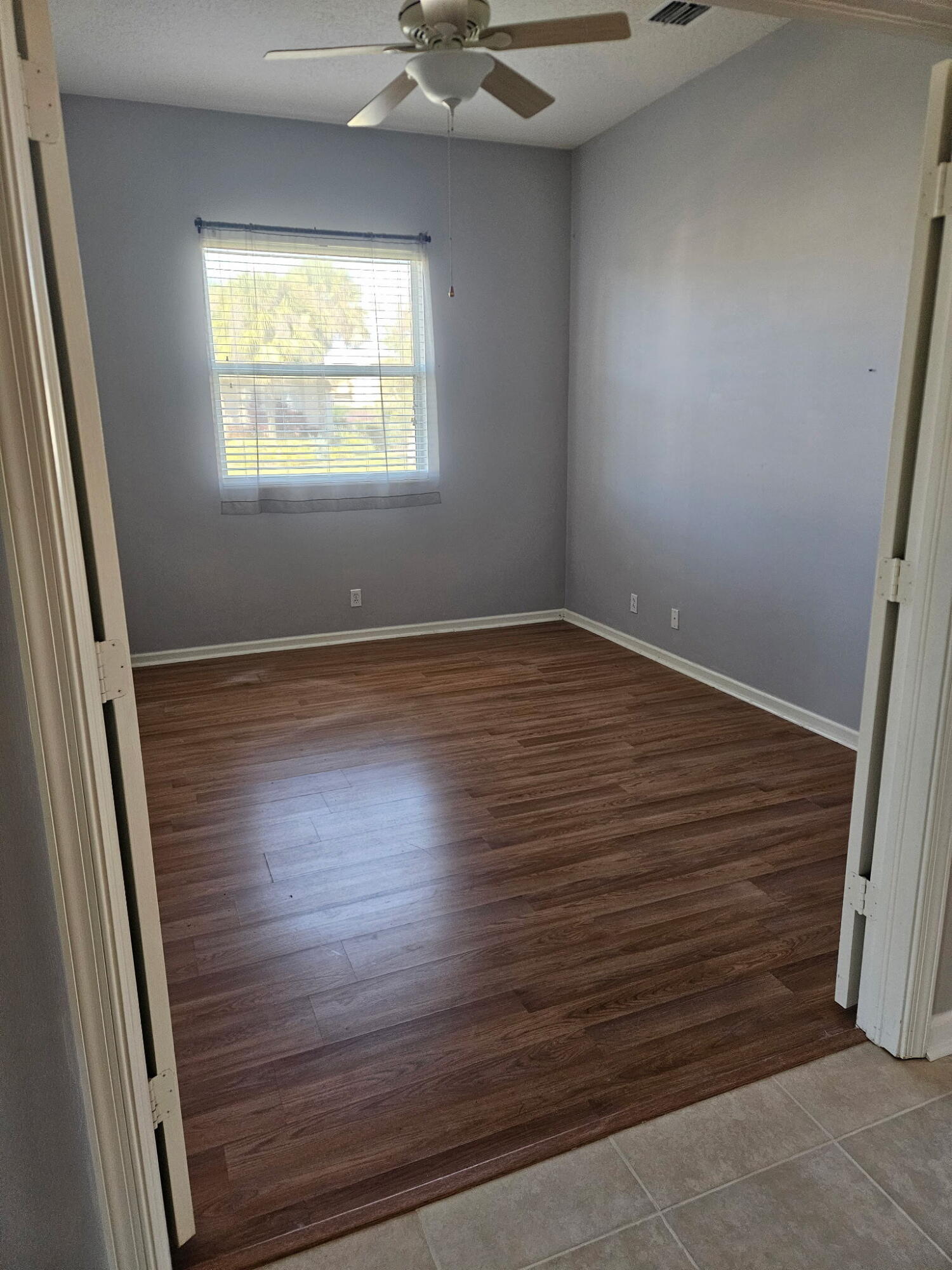 406 Springview Loop Port St. Lucie, FL 34986 - Photo 9 of 23 an empty room with wooden floor and windows