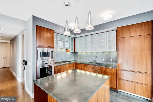 a kitchen with stainless steel appliances granite countertop a sink refrigerator and cabinets