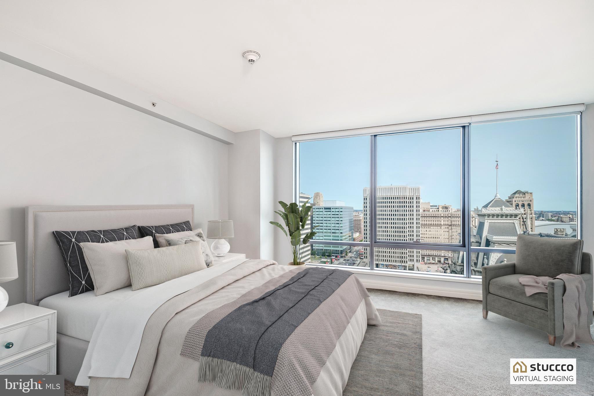 1414 South Penn Square, Unit 20B Philadelphia, PA 19102 - Photo 20 of 54 a spacious bedroom with a bed and a couch with outer view
