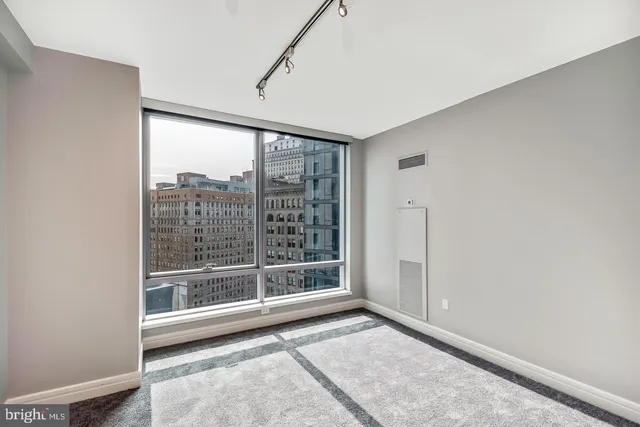 a bedroom with a bed and a large window