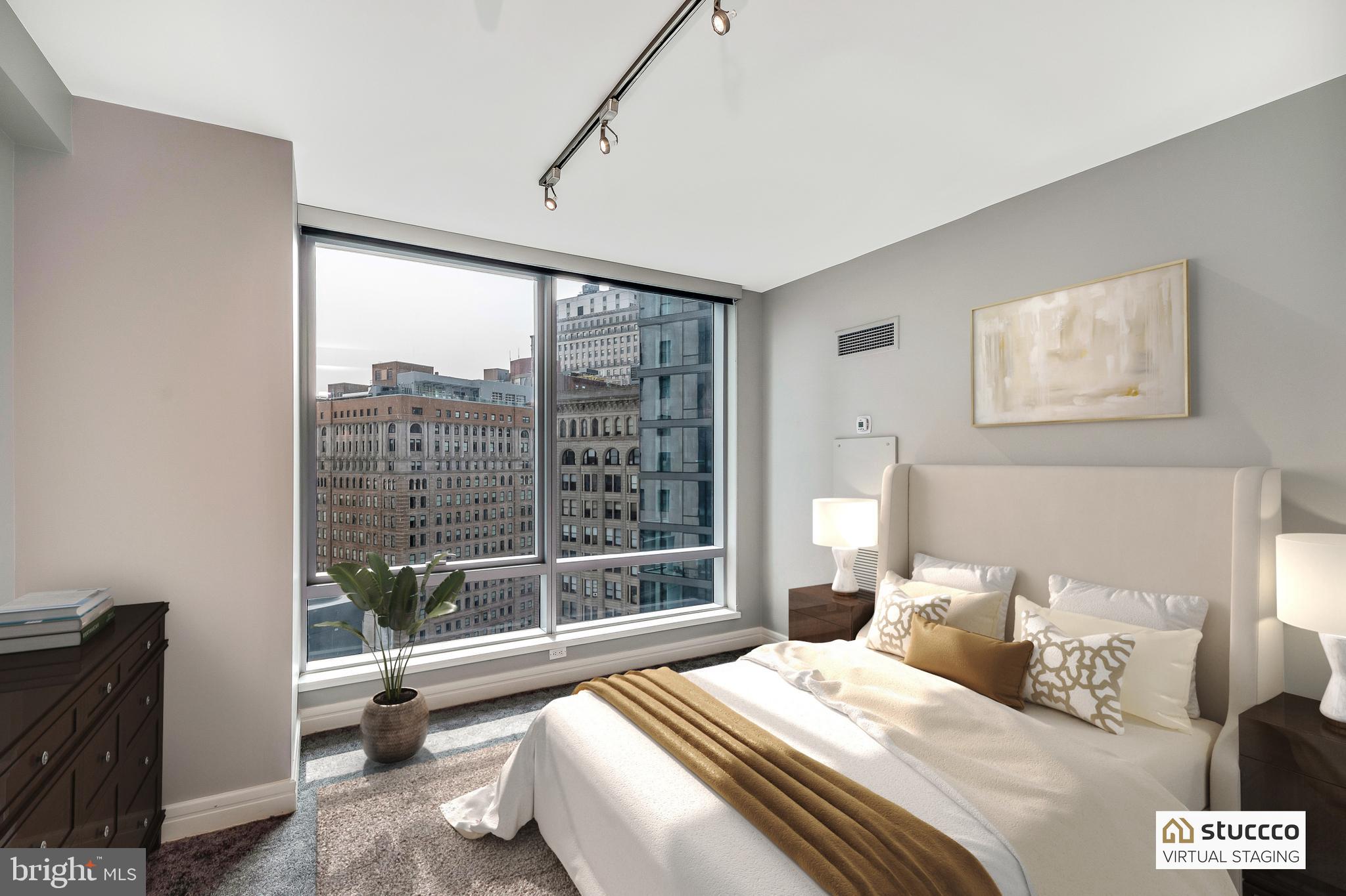 1414 South Penn Square, Unit 20B Philadelphia, PA 19102 - Photo 30 of 54 a bedroom with a bed and a large window