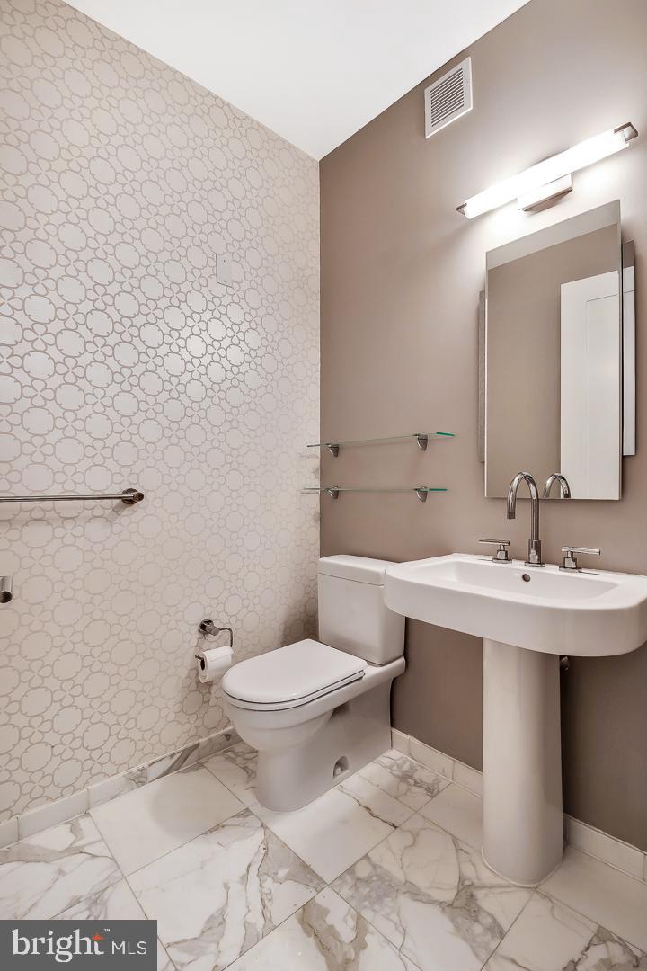 1414 South Penn Square, Unit 20B Philadelphia, PA 19102 - Photo 38 of 54 a bathroom with a toilet a sink and mirror