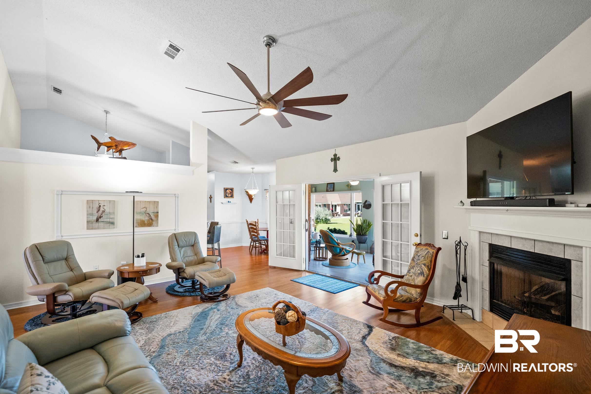 22355 East County Road 12 Foley, AL 36535 - Photo 6 of 54 Living area with lofted ceiling, french doors, a tile fireplace, a ceiling fan, and wood finished floors
