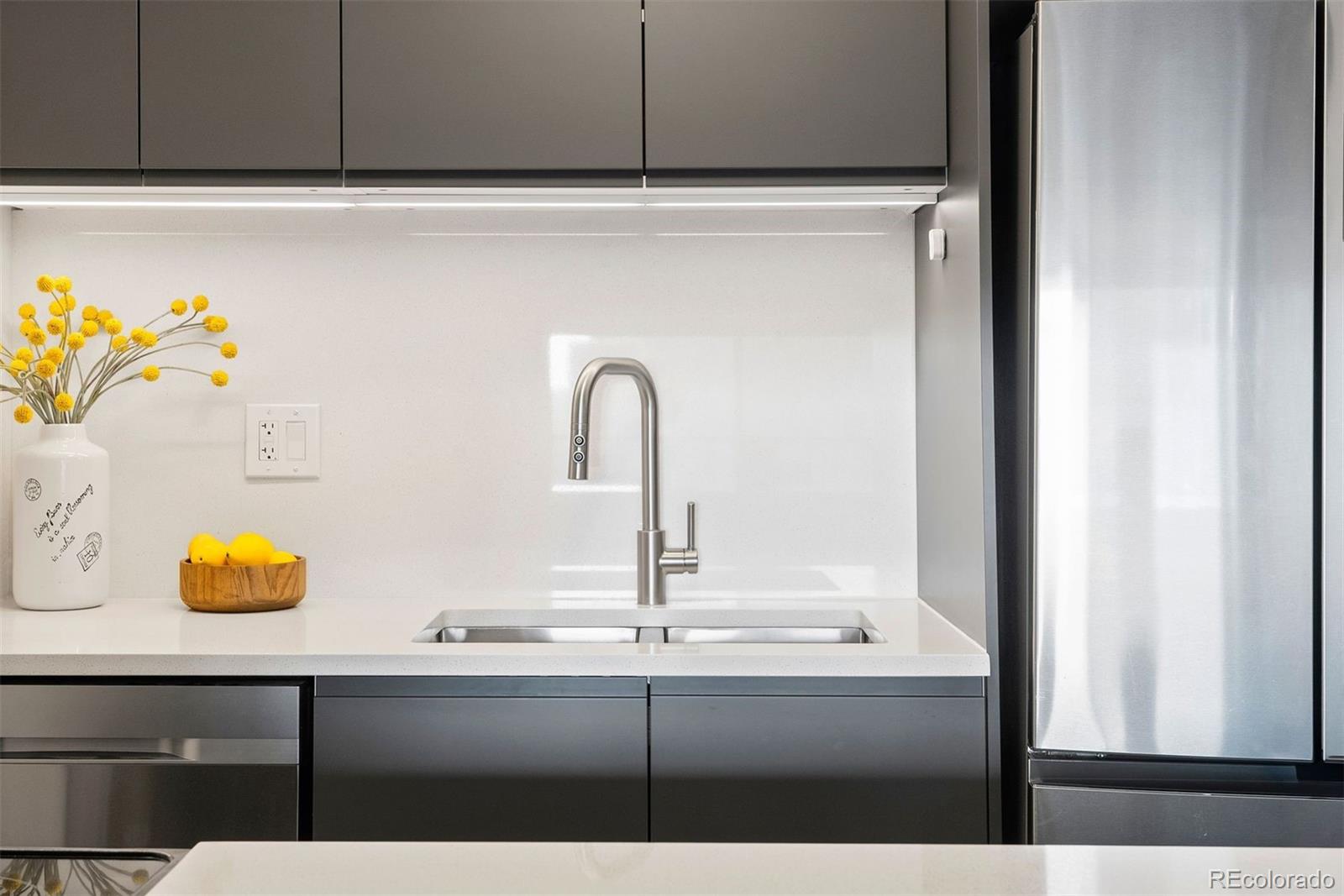 2 Adams Street, Unit 806 Denver, CO 80206 - Photo 18 of 34 a sink with a granite countertop cabinets