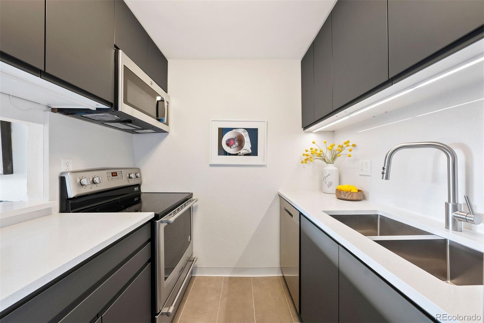 2 Adams Street, Unit 806 Denver, CO 80206 - Photo 2 of 34 a kitchen with stainless steel appliances a sink a stove and cabinets