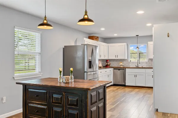 a kitchen with stainless steel appliances granite countertop a sink a refrigerator and a stove