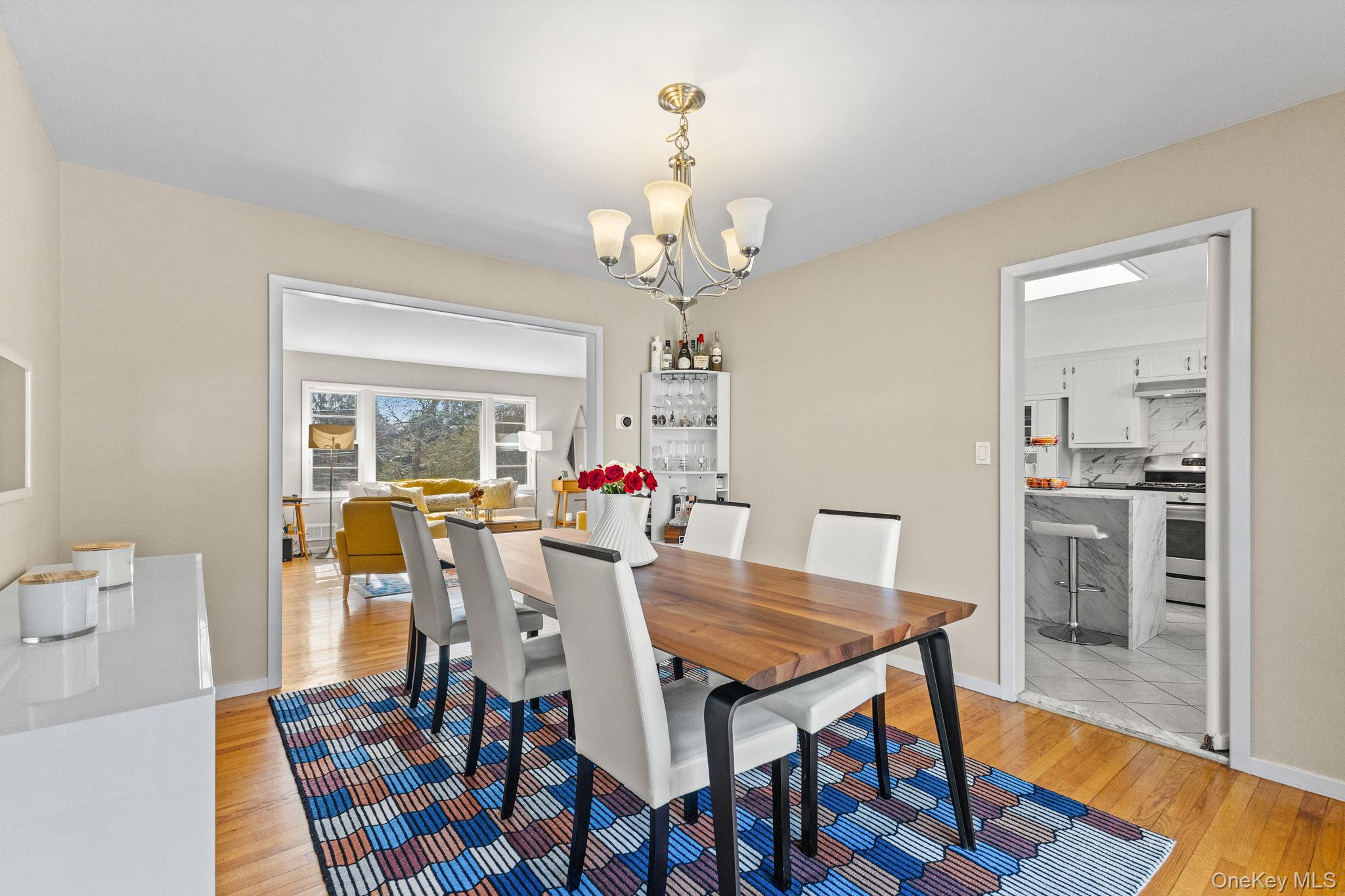 15 Meadow Place Rye, NY 10580 - Photo 11 of 39 Formal dining room off of kitchen and living room with hardwood flooring and chandelier.